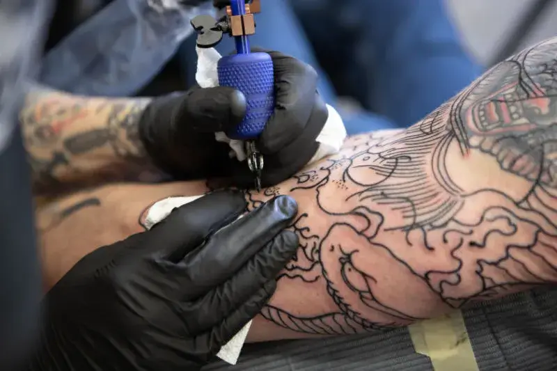 Person being tattooed on their arm.