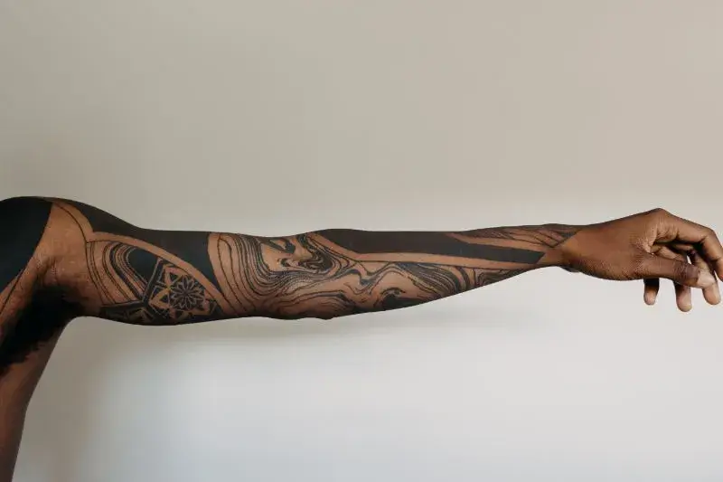 A tattooed arm being stretched showing all tattoos.